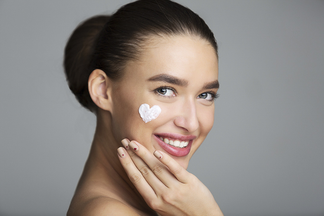 A Women with a heart shaped dab of skin lotion