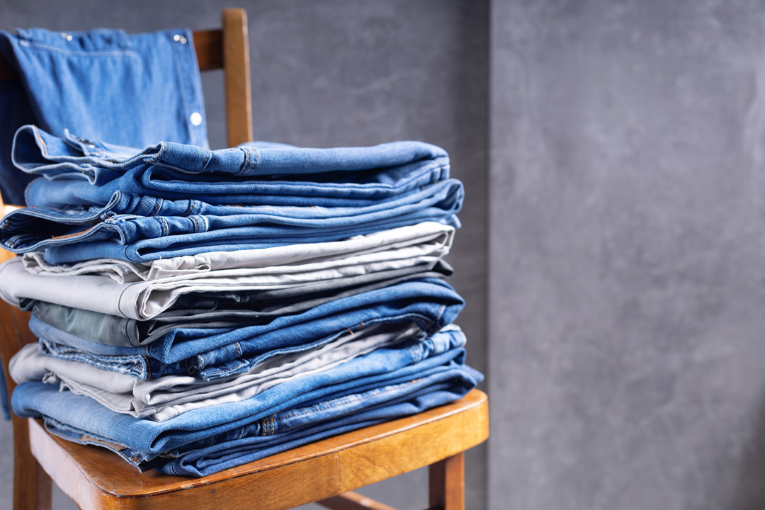 a pile of jeans on a chair